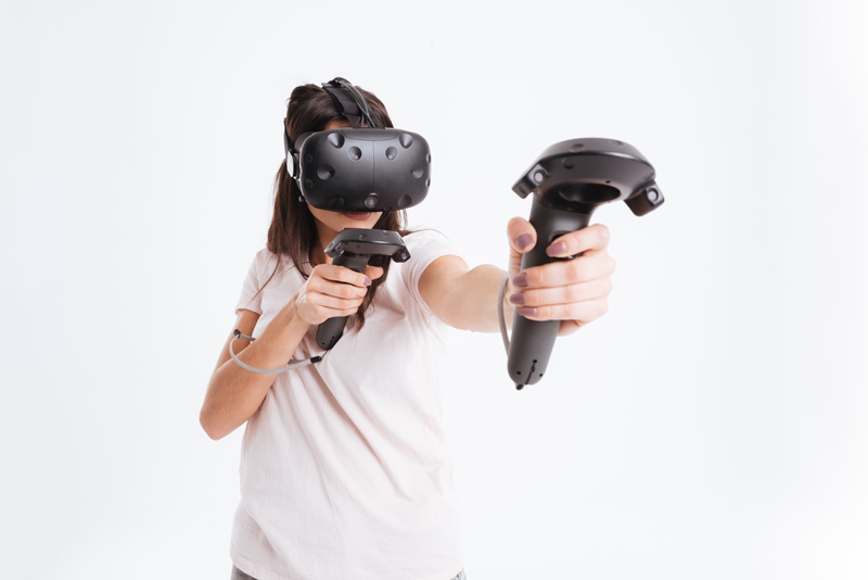 Someone wearing a virtual reality visor and interacting with the virtual world using joysticks