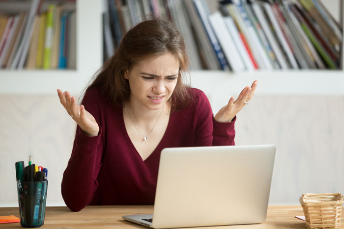 image of a woman looking bewildered in front of a PC