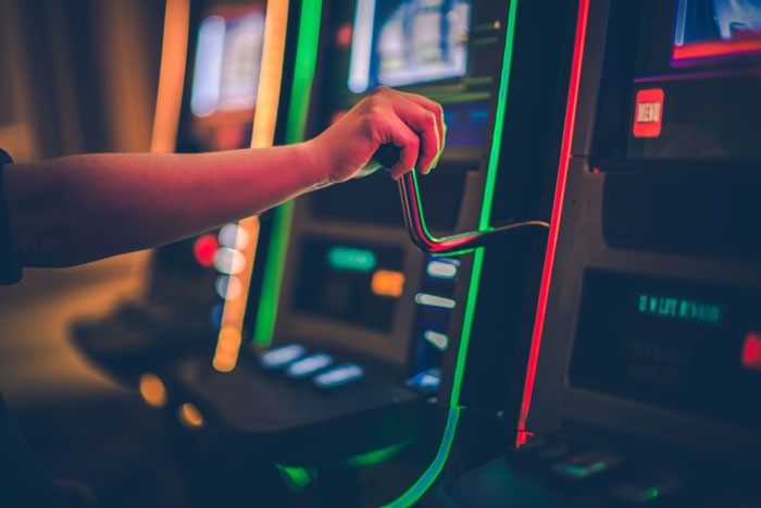 Un braccio che sta per azionare la leva di una slot machine